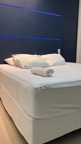 uma cama branca com uma cabeceira azul e lençóis brancos em Casa Almirante Premium em Macapá