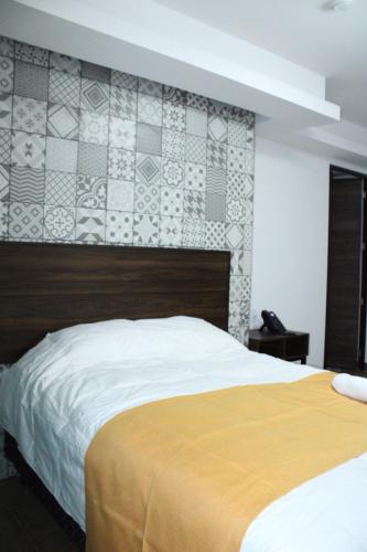 ein Schlafzimmer mit einem großen Bett und einer Wand mit Fliesen in der Unterkunft Rincon de Hidalgo in San Juan del Río