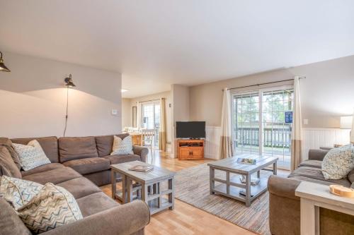 a living room with a couch and a tv at Slack Tide - Meredith Lodging in Seaside