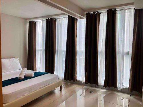 a bedroom with a bed and large windows at Great Value in Uptown Parksuites BGC 1BR,Washer,Netflix in Manila