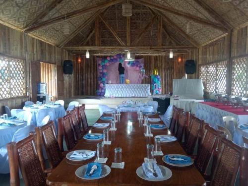 a long dining room with a long table and chairs at Gratum Beach Resort in Dapitan