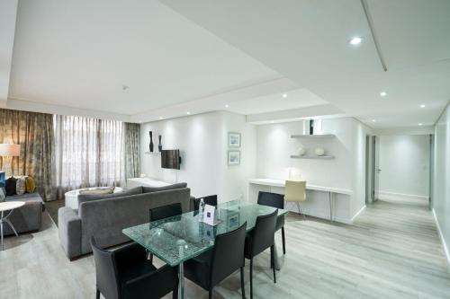 a living room with a table and a couch at Protea Hotel by Marriott Cape Town North Wharf in Cape Town