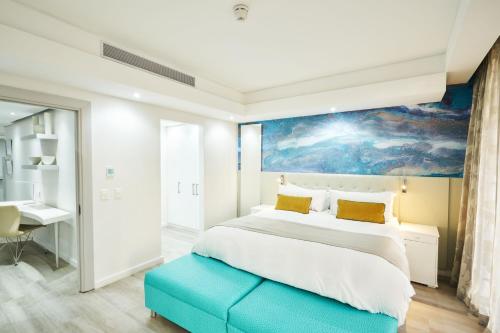a bedroom with a large bed with a painting on the wall at Protea Hotel by Marriott Cape Town North Wharf in Cape Town