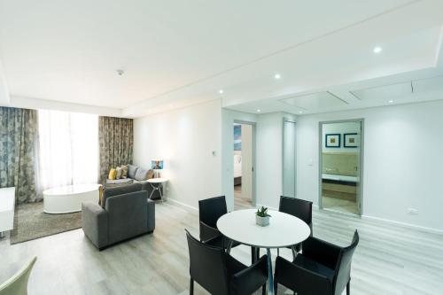 a living room with a table and chairs and a couch at Protea Hotel by Marriott Cape Town North Wharf in Cape Town
