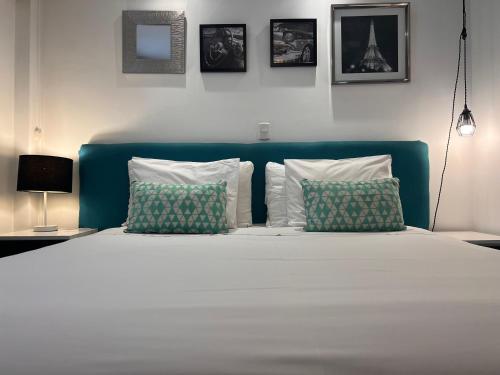 a bedroom with a bed with a blue headboard and pillows at La Casa del Viajero in Lima