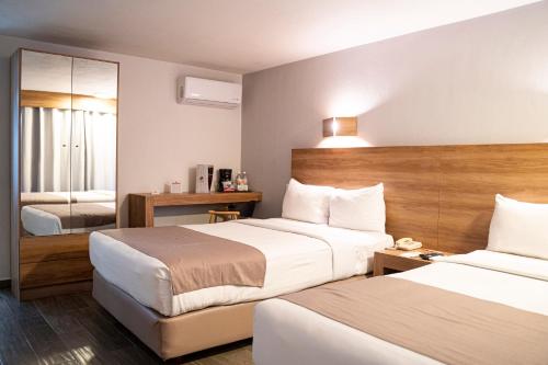 Tempat tidur dalam kamar di La Posada Hotel y Suites