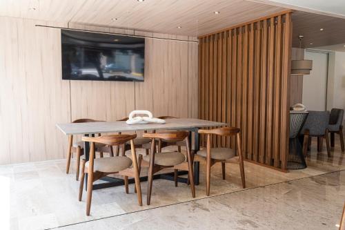 una sala da pranzo con tavolo e sedie in legno di La Posada Hotel y Suites a San Luis Potosí