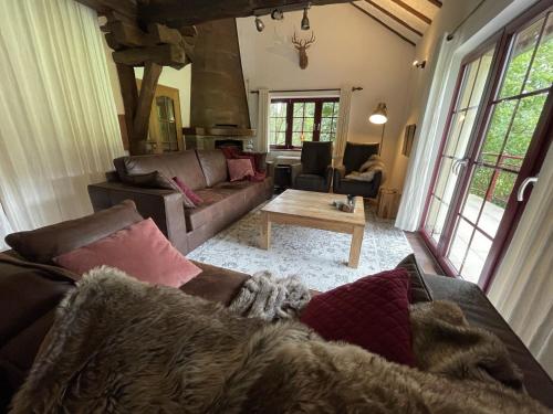 uma sala de estar com um sofá e uma mesa em Ardennes villa with riverside garden and views em Atzerath