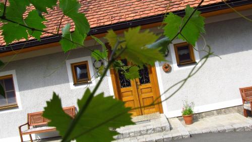 a house with a wooden door with benches in front at Weingut Dietl in Riegersburg