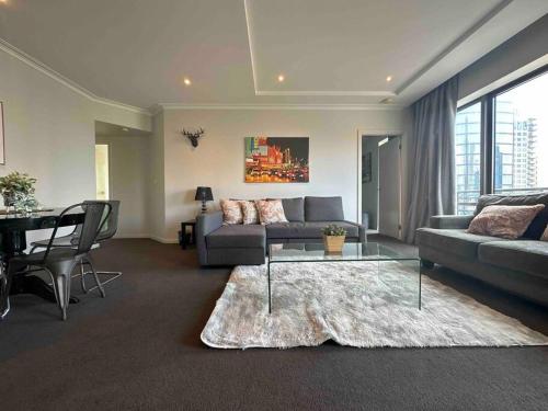 a living room with a couch and a table at HeartCBD LUX Top Floor 2 Bedroom /Pool/Spa/GYM in Melbourne