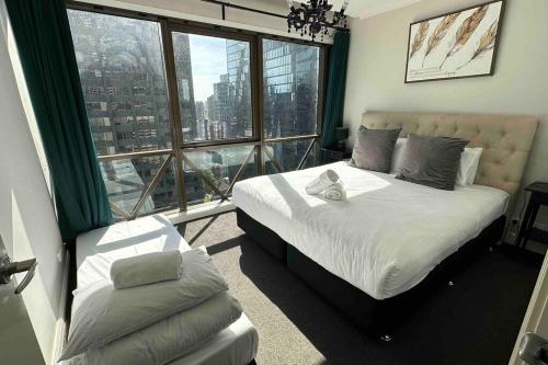 1 dormitorio con cama y ventana grande en HeartCBD LUX Top Floor 2 Bedroom /Pool/Spa/GYM, en Melbourne