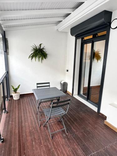 a patio with a table and chairs on a wooden floor at Cyrus appartements in Pointe-à-Pitre