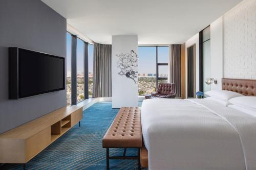 a hotel room with a bed and a flat screen tv at Four Points by Sheraton Shanghai Hongqiao in Shanghai