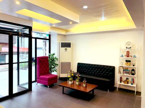 a living room with a couch and a red chair at Crosswinds Hotel in Manila