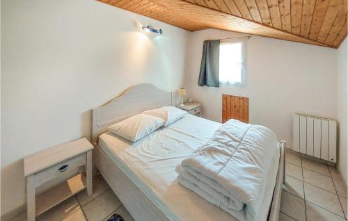 een slaapkamer met een wit bed en een tafel bij Amazing Home In Les Sables Dolonne With Kitchen in Saint-Martin-de-Brem