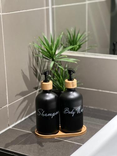 two black bottles sitting on a bathroom counter at KASOTA SUITE Aeropod Sovo-Near KKCity-Near Airport in Tanjong Aru