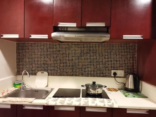 a kitchen with a sink and a stove top oven at Greenage MingSuite 明绿时代套房 Kota Kinabalu 亚庇市中心 in Kota Kinabalu
