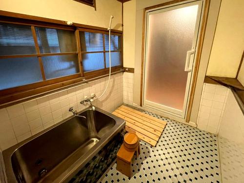 La salle de bains est pourvue d'une baignoire et d'une fenêtre. dans l'établissement Yananose house, 