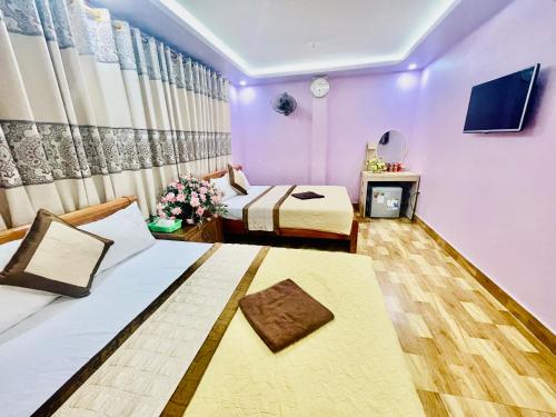 a hotel room with two beds and a tv at Pink Boutique Inn - Hotel Elite in Cat Ba