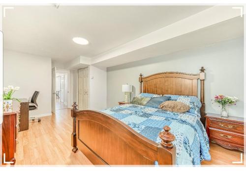 1 dormitorio con cama de madera y edredón azul en Leila`s place-Basement apartment in private home en Gatineau
