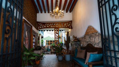 a living room with a couch and a chandelier at Hotel Casa del Fraile in Morelia