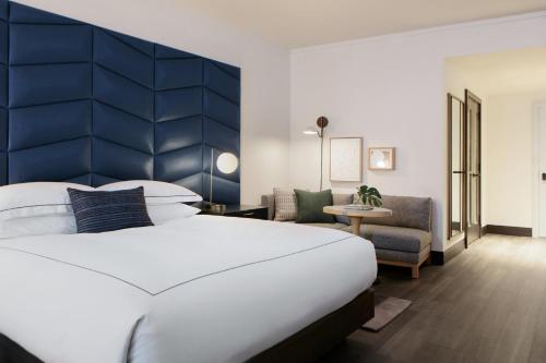 a bedroom with a large white bed and a blue headboard at Kimpton Shane Atlanta by IHG in Atlanta