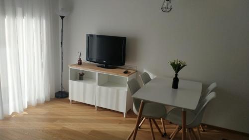 a living room with a tv and a table with chairs at A Casa di Gioia in Castel di Sangro