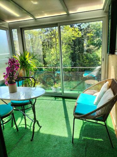 une pièce avec une table et des chaises et une grande fenêtre dans l'établissement L'esprit de famille, à Semur-en-Auxois