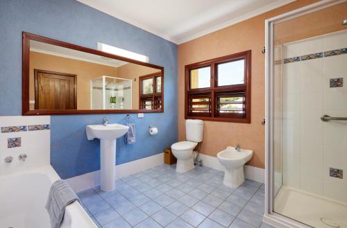 a bathroom with two toilets and a sink and a shower at Tropical Styling in Cooktown