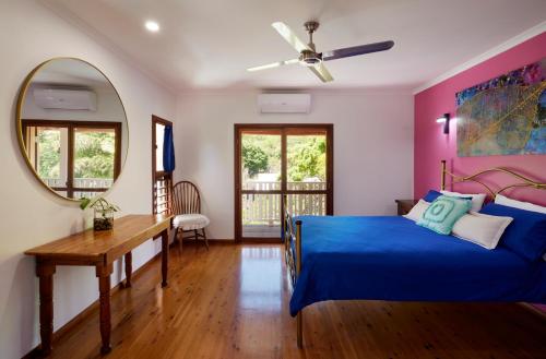a bedroom with a blue bed and a mirror at Tropical Styling in Cooktown