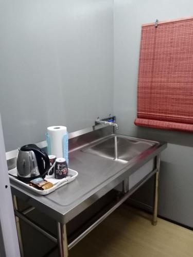 a kitchen counter with a sink in a room at Homestay Pinang Tunggal Cabin in Sungai Petani