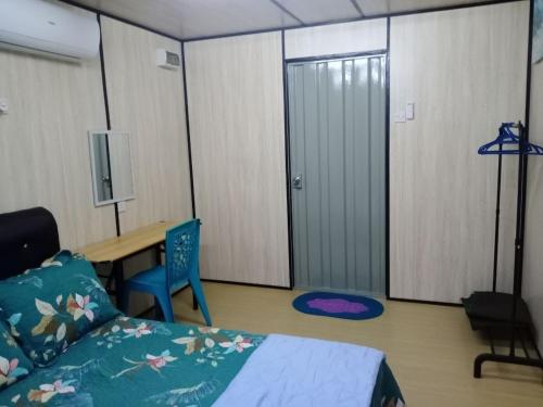 a bedroom with a bed and a desk and a table at Homestay Pinang Tunggal Cabin in Sungai Petani