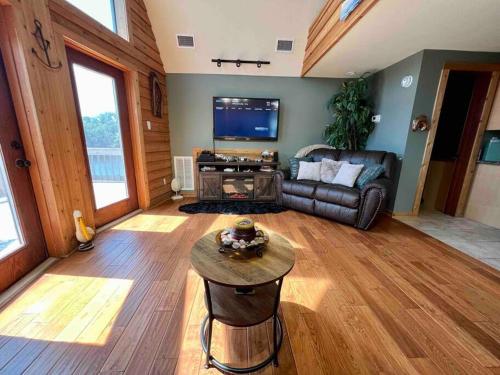 ein Wohnzimmer mit einem Sofa und einem Tisch in der Unterkunft Secluded cabin on the water with jet skis, kayaks, & hot tub! Pet friendly in Satsuma