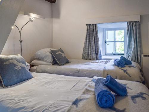 um quarto com 2 camas com toalhas azuis em No Place em Sennen