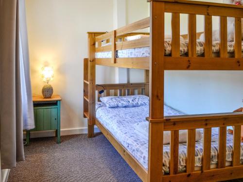 a bedroom with two bunk beds and a table at Stoneybeck-uk45044 in Greenhead