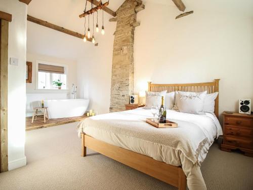 Little Badger Cottage في Kirkburton: غرفة نوم بسرير كبير وحوض استحمام