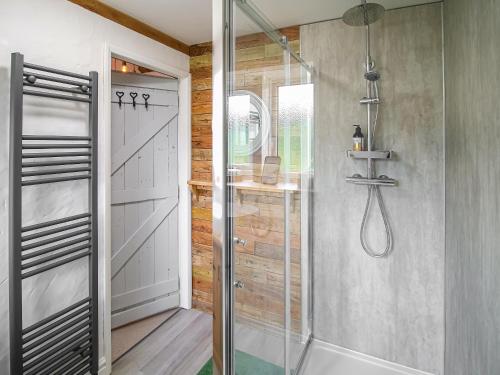 a shower with a glass door in a bathroom at Little Badger Cottage in Kirkburton