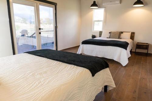 2 łóżka w pokoju z balkonem w obiekcie VALLE LIFE w mieście Sansoni