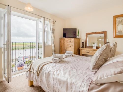 a bedroom with a bed with a view of the ocean at Yare Cottage in Reedham