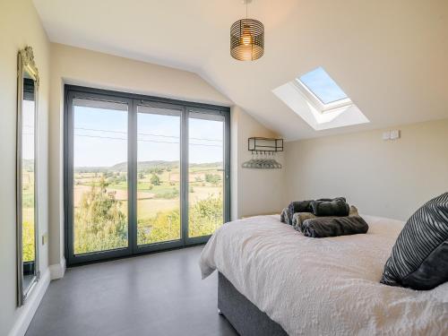 a bedroom with a bed and a large window at Wye Nest in Fownhope