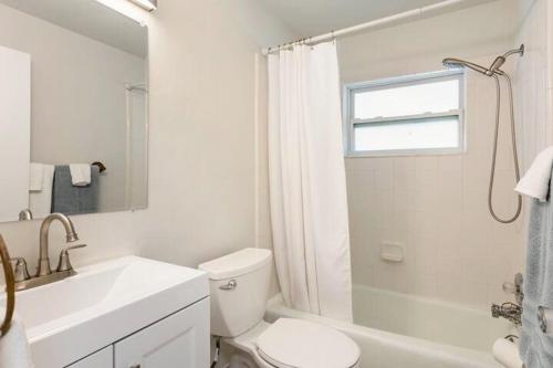 La salle de bains blanche est pourvue de toilettes et d'un lavabo. dans l'établissement Sunny Shores Retreat 2, à Clearwater Beach