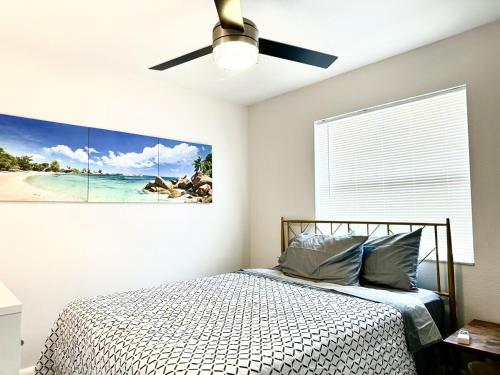 a bedroom with a bed and a painting on the wall at Sandy Beach Sunset West in Clearwater Beach