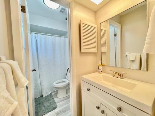 a bathroom with a sink and a toilet and a mirror at Sandy Beach Sunset East in Clearwater Beach
