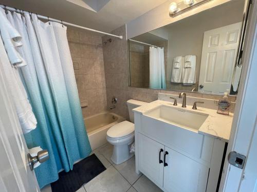 uma casa de banho com um lavatório, um WC e um espelho. em Beachside Getaway West em Clearwater Beach