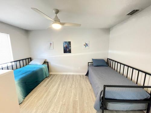a bedroom with two beds and a ceiling fan at Beachside Getaway West in Clearwater Beach