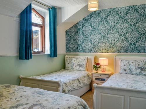 2 łóżka w sypialni z niebieską tapetą w obiekcie Millstream - Uk45183 w mieście Penton