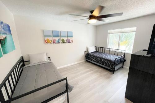 a bedroom with two beds and a ceiling fan at Beachside Getaway East in Clearwater Beach