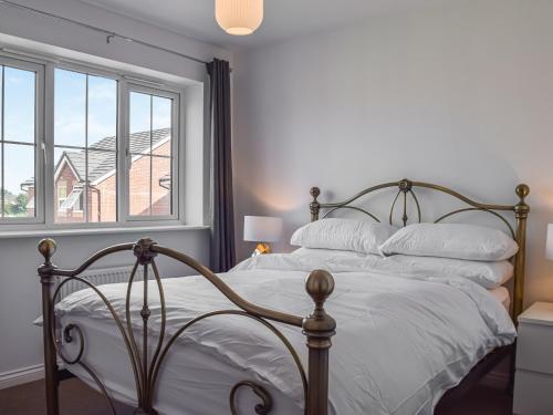 a bedroom with a bed with white sheets and a window at The Goldsmith in Blackpool