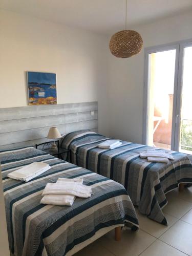 une chambre avec deux lits avec des serviettes dessus dans l'établissement punta di buturetu, à Propriano