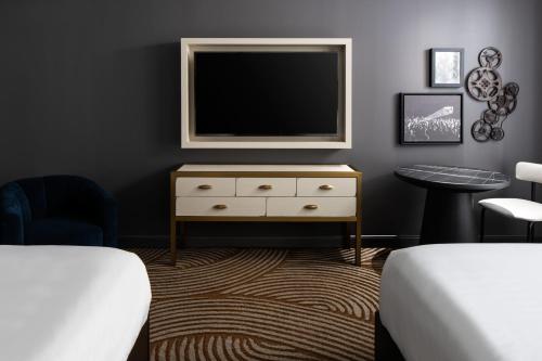 a bedroom with a tv on top of a dresser at Trilith Guesthouse, Fayetteville, GA, a Tribute Portfolio Hotel in Fayetteville